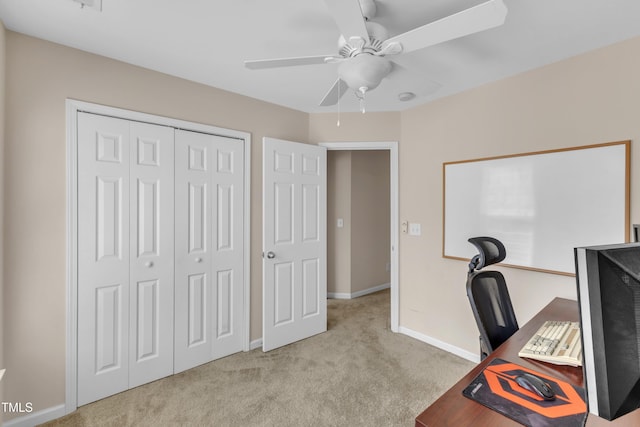 unfurnished office with carpet floors, ceiling fan, and baseboards
