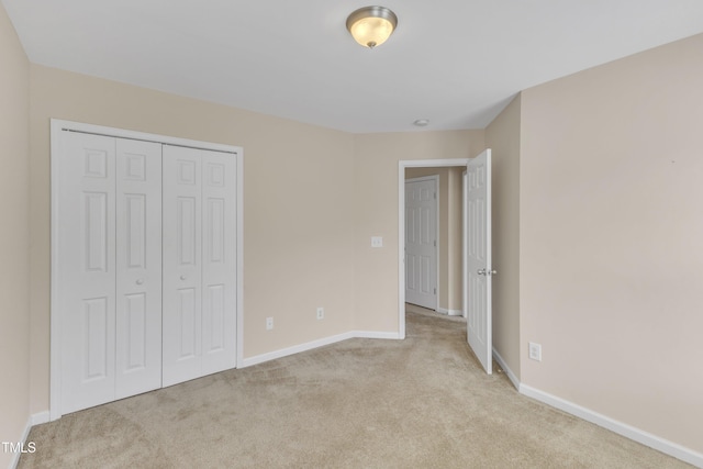 unfurnished bedroom featuring baseboards, carpet, and a closet