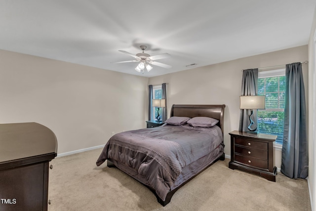 bedroom with baseboards, ceiling fan, and light carpet