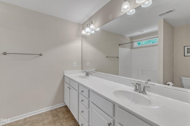 bathroom with visible vents, a sink, baseboards, and double vanity