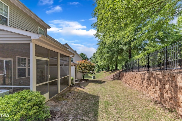 view of yard featuring a sunroom and fence