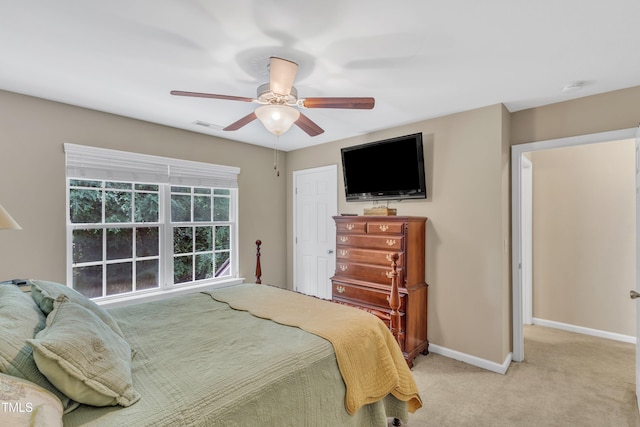 bedroom featuring baseboards, light colored carpet, and a ceiling fan