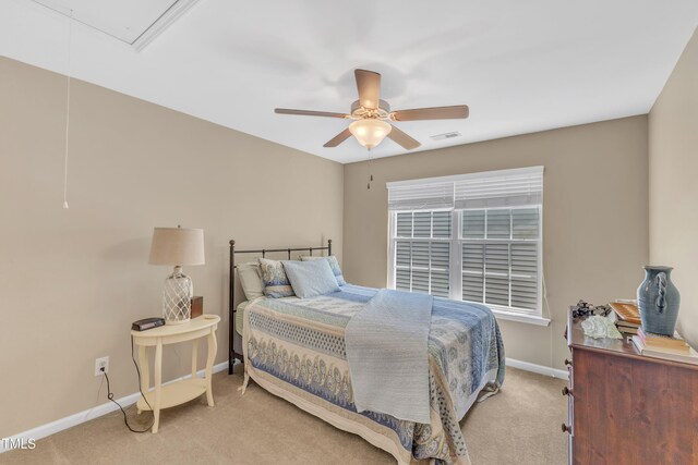 bedroom featuring light carpet, baseboards, attic access, and ceiling fan