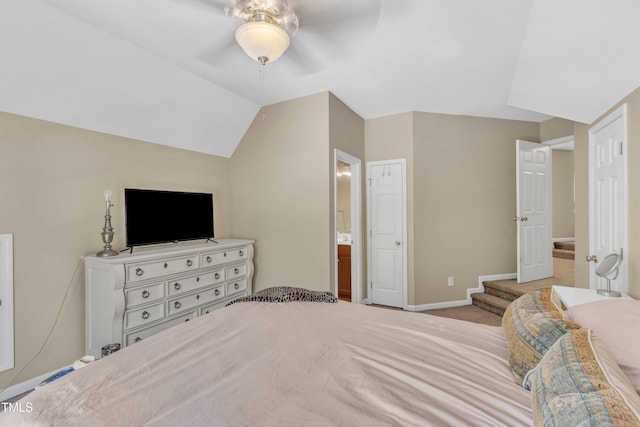 carpeted bedroom featuring baseboards, ceiling fan, lofted ceiling, and ensuite bathroom