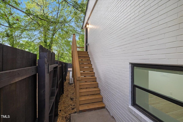 view of side of home with fence and stairway