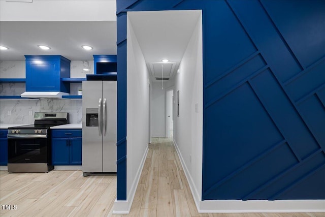 hall with attic access and light wood-style flooring