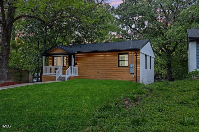 chalet / cabin featuring covered porch and a front yard
