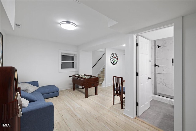 rec room with baseboards, visible vents, and light wood-type flooring