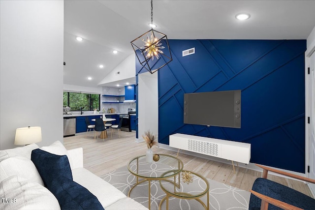 living room with recessed lighting, lofted ceiling, light wood-type flooring, and visible vents