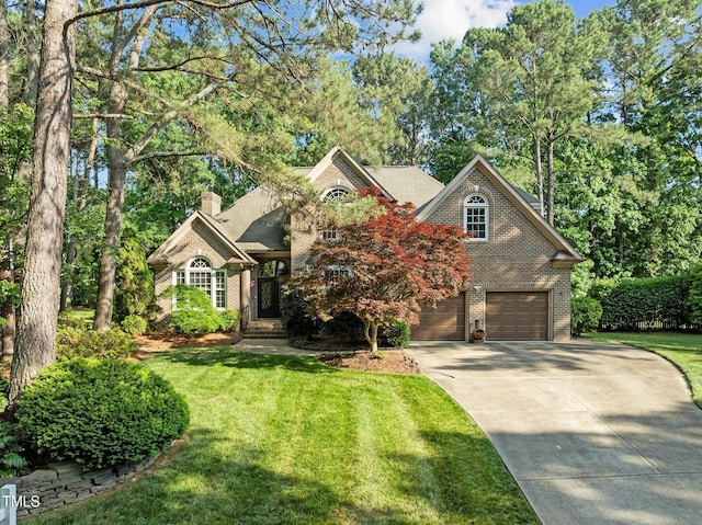 traditional-style house with brick siding, driveway, a garage, a chimney, and a front lawn