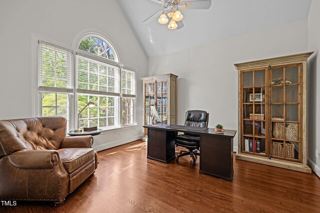 office area featuring a ceiling fan, plenty of natural light, high vaulted ceiling, baseboards, and dark wood-type flooring