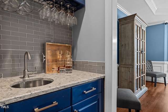 bar with a sink, crown molding, backsplash, and dark wood-style flooring