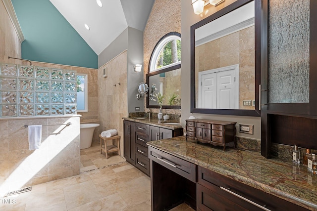 full bathroom with tile walls, a freestanding tub, vanity, high vaulted ceiling, and walk in shower