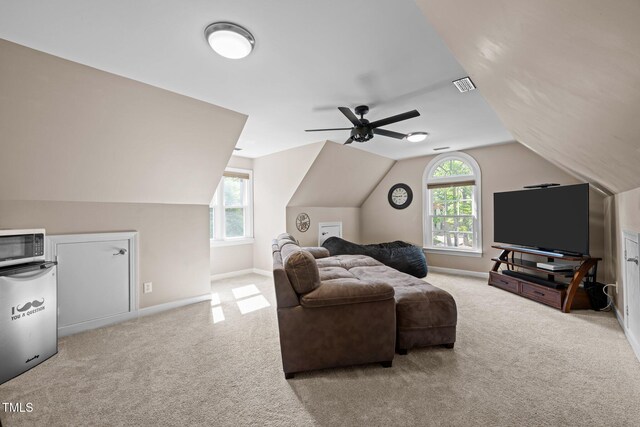 living room featuring carpet flooring, vaulted ceiling, baseboards, and ceiling fan