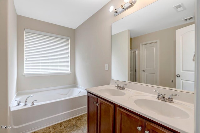 bathroom featuring visible vents, a sink, a bath, and double vanity