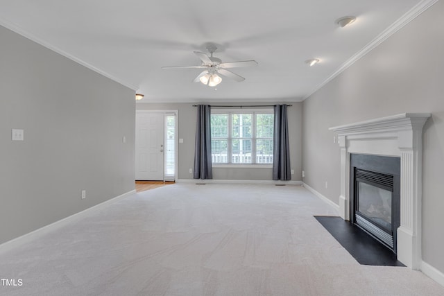unfurnished living room featuring carpet, a ceiling fan, baseboards, a fireplace with flush hearth, and ornamental molding