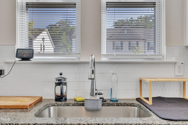 room details featuring stone countertops, a sink, and tasteful backsplash