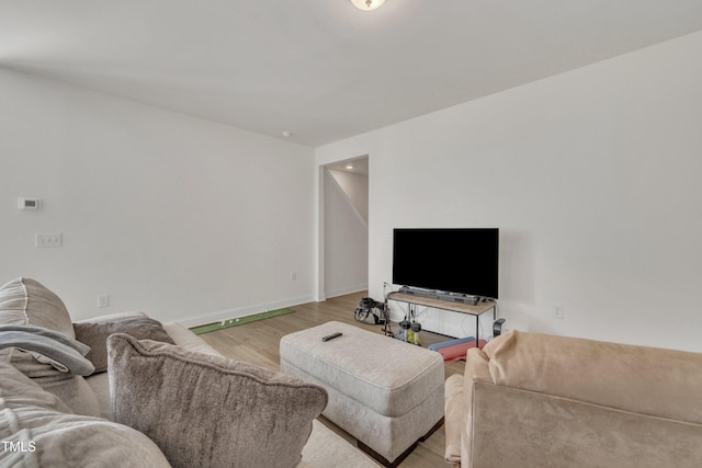 living room featuring baseboards and light wood-type flooring