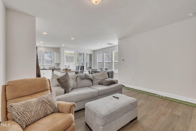 living area with recessed lighting, baseboards, visible vents, and light wood-style floors