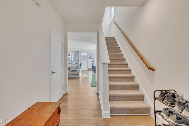 stairs with baseboards, recessed lighting, and wood finished floors
