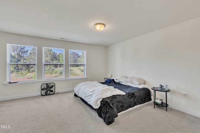 bedroom with baseboards, carpet flooring, visible vents, and multiple windows