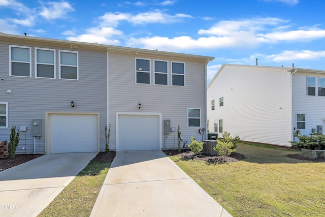 view of front of property with an attached garage, central AC, a front yard, and concrete driveway
