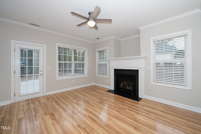 unfurnished living room featuring light wood-type flooring, plenty of natural light, crown molding, and ceiling fan