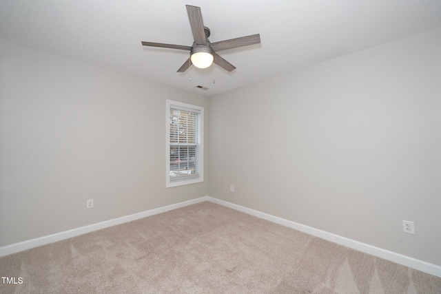 carpeted empty room with baseboards, visible vents, and ceiling fan