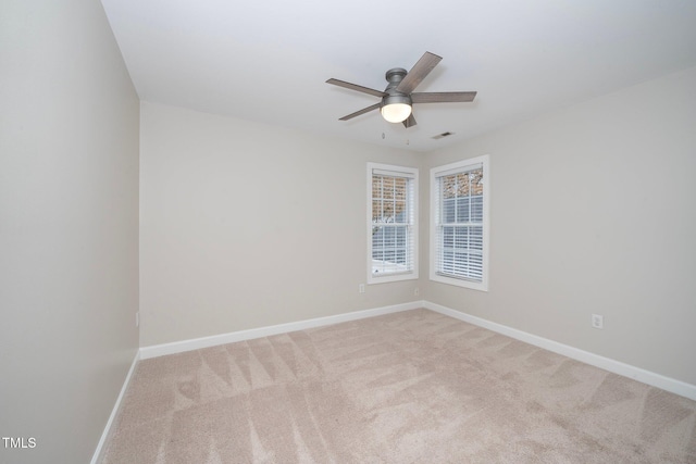 unfurnished room with baseboards, ceiling fan, carpet, and visible vents
