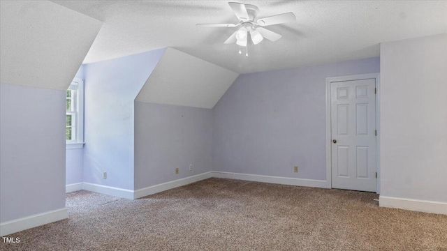 bonus room with lofted ceiling, a textured ceiling, ceiling fan, carpet floors, and baseboards
