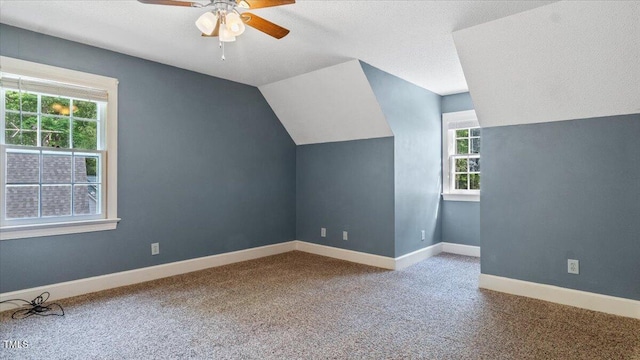 bonus room featuring carpet, vaulted ceiling, baseboards, and a ceiling fan