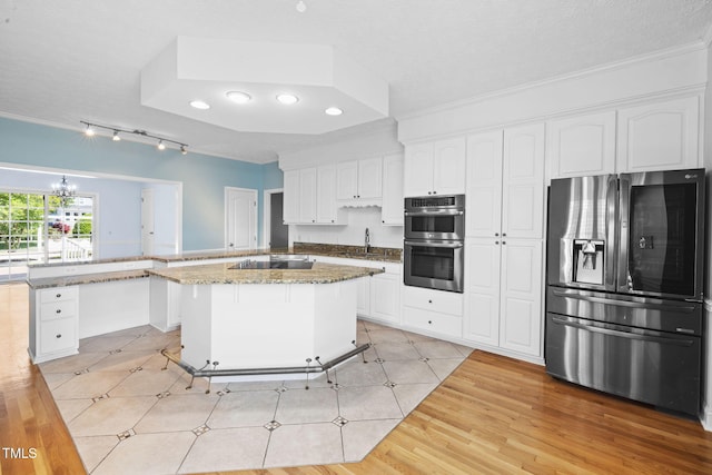 kitchen featuring stainless steel appliances, a peninsula, track lighting, ornamental molding, and white cabinetry