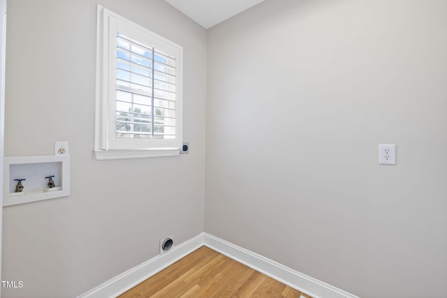 laundry area with electric dryer hookup, washer hookup, baseboards, and light wood finished floors