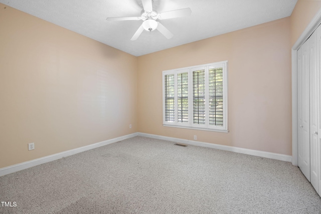 unfurnished bedroom with a closet, carpet, baseboards, and a ceiling fan