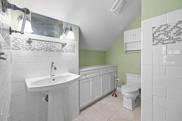 bathroom featuring vaulted ceiling, tile patterned flooring, and toilet