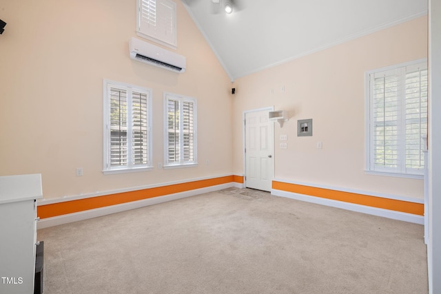 carpeted spare room featuring an AC wall unit, crown molding, baseboards, and high vaulted ceiling