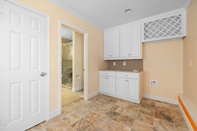 clothes washing area featuring baseboards, stone finish floors, crown molding, and recessed lighting