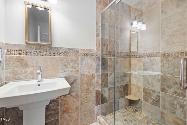 full bathroom featuring a shower stall, tile walls, and a wainscoted wall