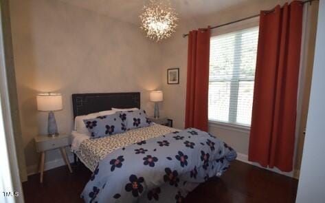 bedroom featuring baseboards and a chandelier