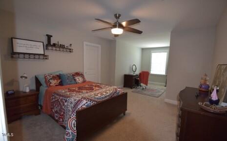 bedroom with baseboards, ceiling fan, and light colored carpet
