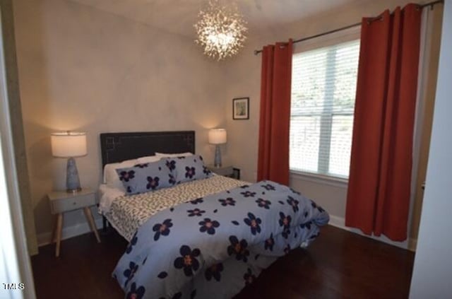 3032 Curling Creek Dr, Apex, NC 27502 - bedroom featuring baseboards, multiple windows, wood finished floors, and a notable chandelier