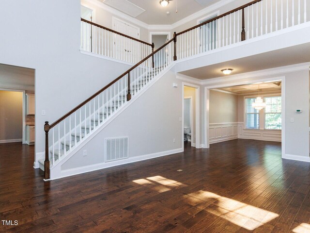 354 Crimson Way, Pittsboro, NC 27312 - unfurnished living room with a chandelier, stairway, a high ceiling, hardwood / wood-style flooring, and ornamental molding