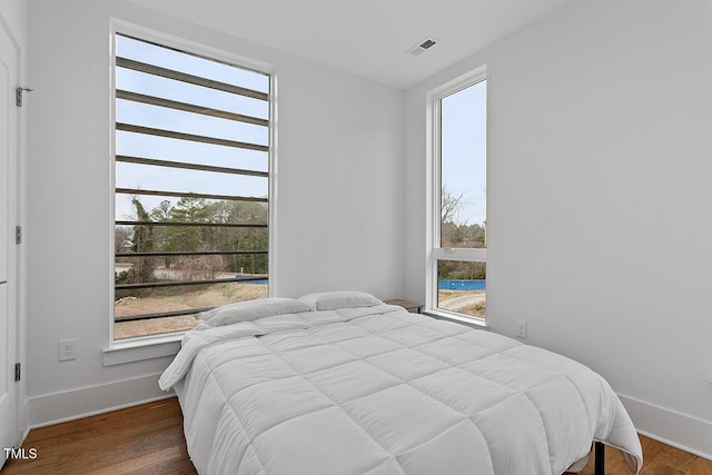 bedroom with baseboards and wood finished floors