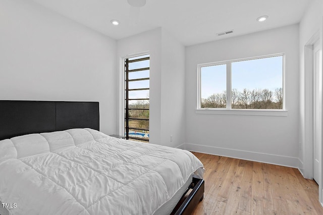 bedroom featuring baseboards, light wood-style floors, and recessed lighting