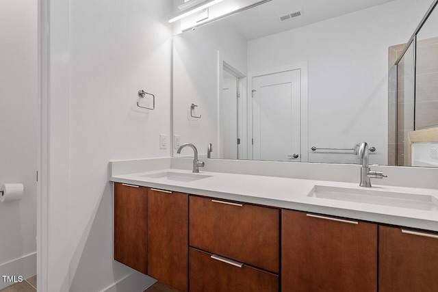 full bathroom featuring double vanity and a shower with door