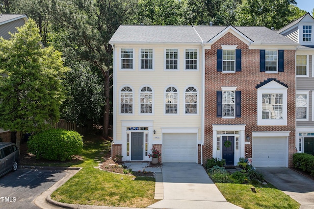townhome / multi-family property with driveway and brick siding