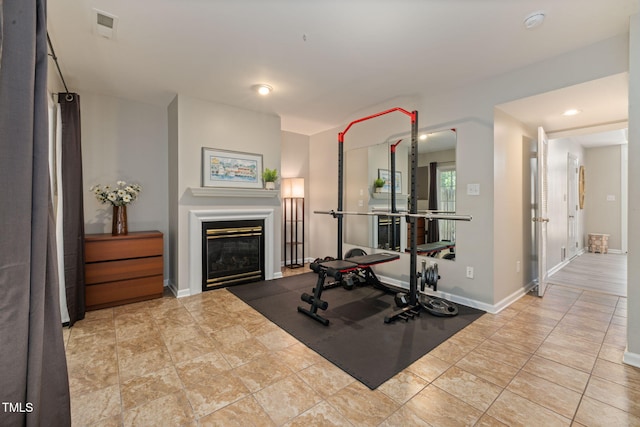 workout area featuring visible vents, recessed lighting, baseboards, and a glass covered fireplace