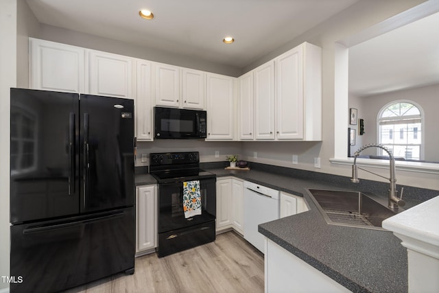 kitchen featuring a sink, dark countertops, white cabinets, and black appliances