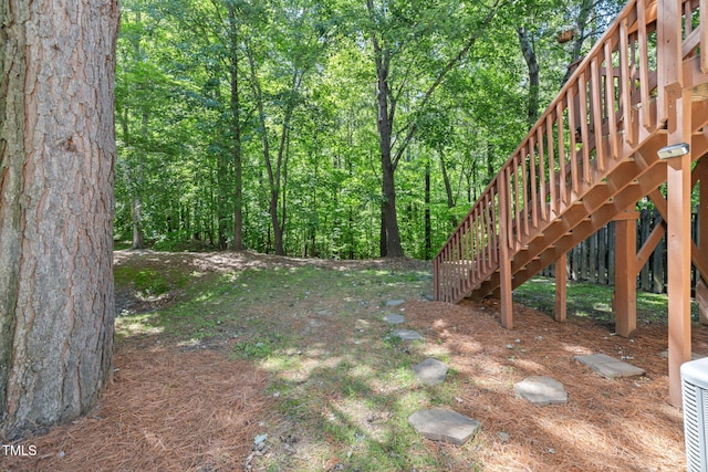 view of yard featuring stairs and a wooded view