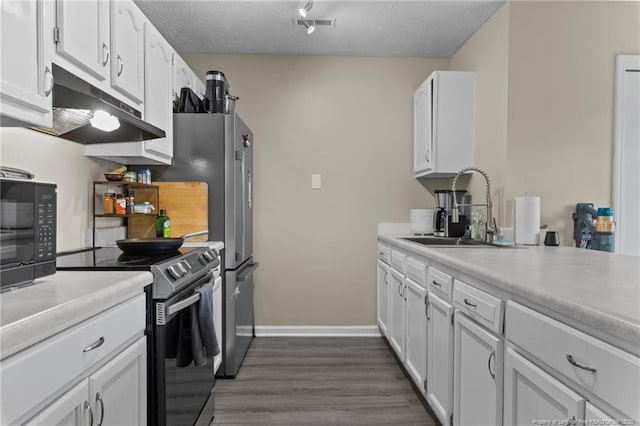 kitchen featuring a sink, white cabinets, under cabinet range hood, and range with electric cooktop